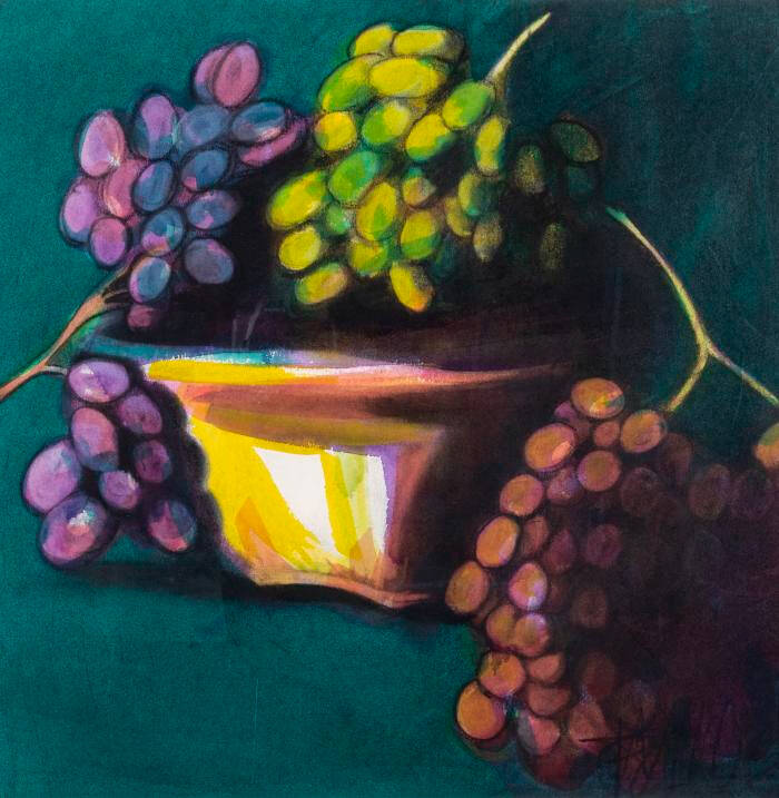 Image of bunches of grapes, purple, red, and gree, sitting in or near a gold colored container.